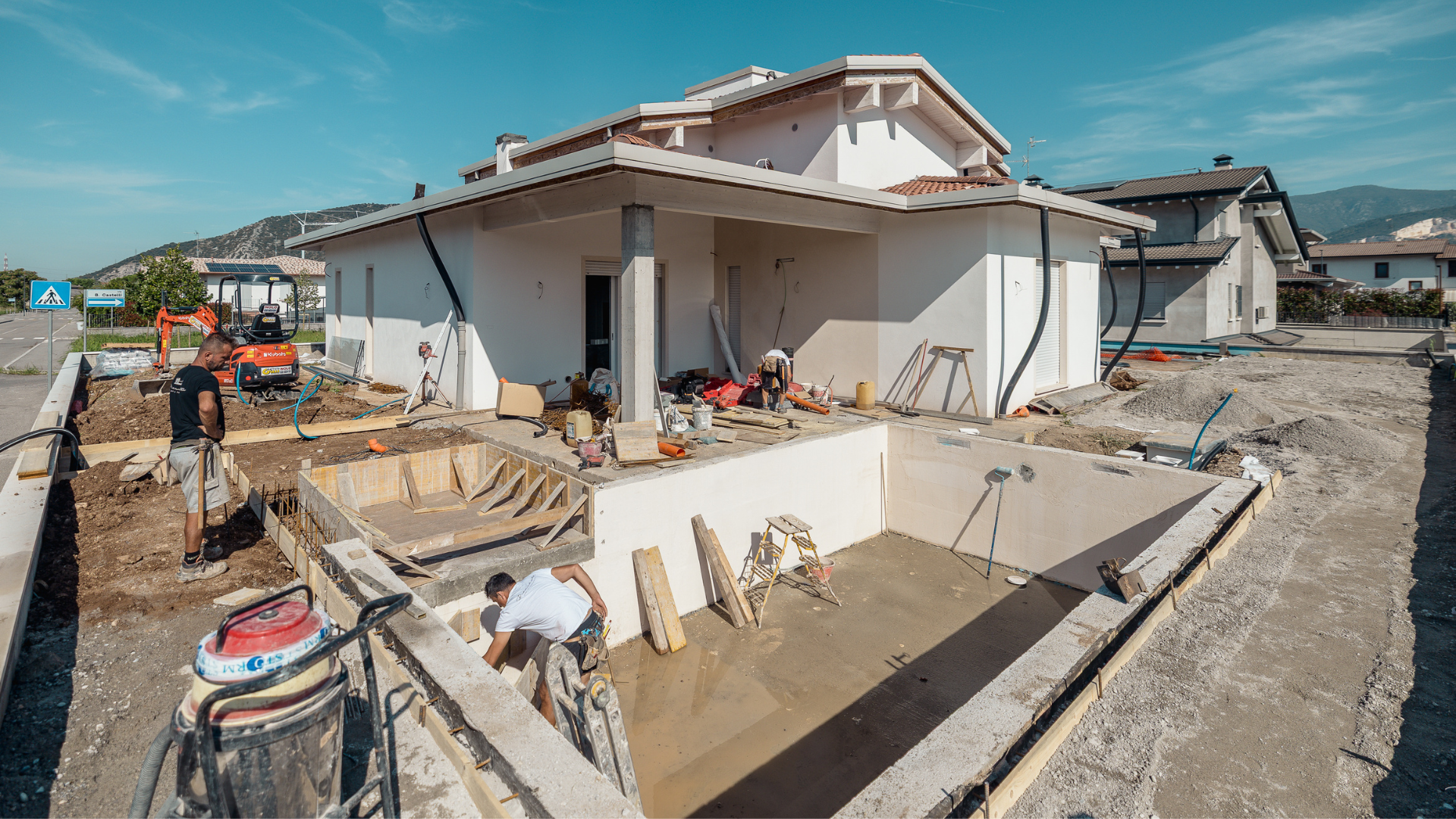 Lavori di cantiere in corso per la costruzione di una piscina interrata nel giardino di una villa residenziale, coordinati da Bianchetti General Contractor.