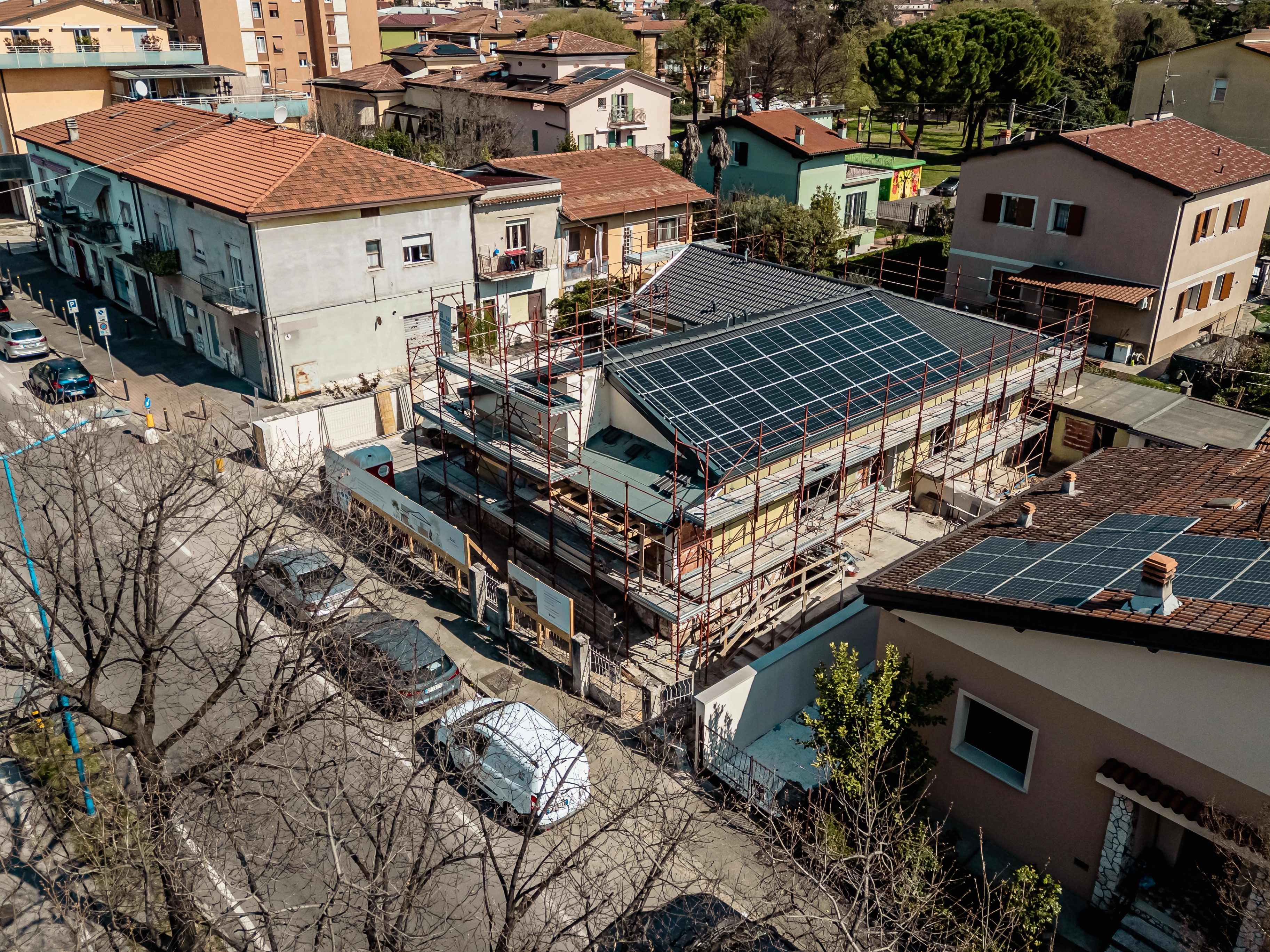 Panoramica aerea di un cantiere Bianchetti con ponteggi esterni e installazione di un grande impianto fotovoltaico per l'efficienza energetica dell'edificio.